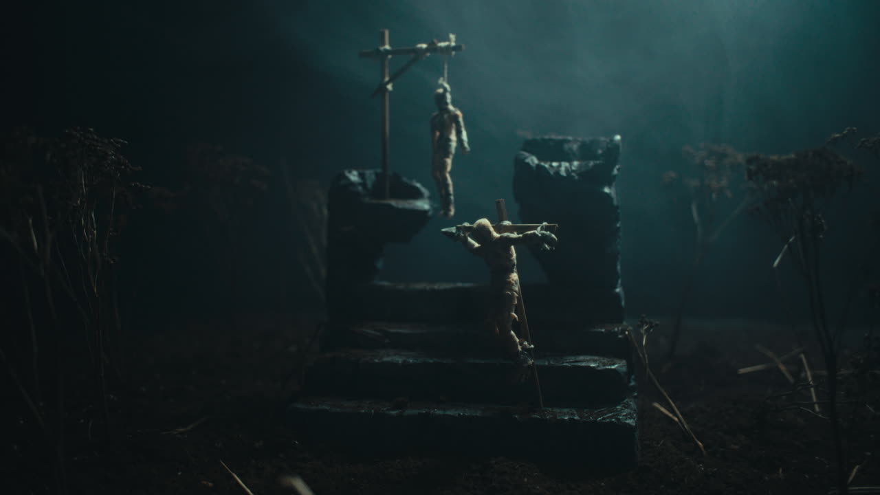 A miniature scene of the mummified dolls hanging on the gallows at night