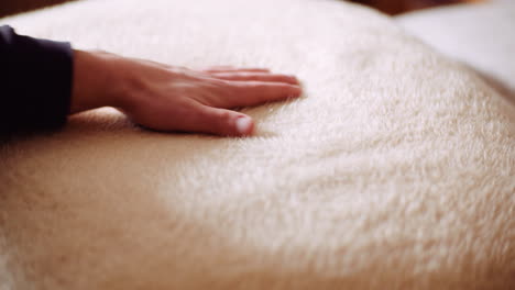 man touching smooth blanket close-up