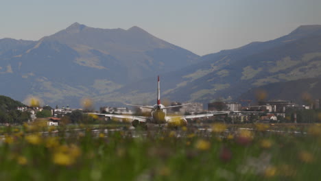 airplane taking off or landing at innsbruck airport with mountains in background