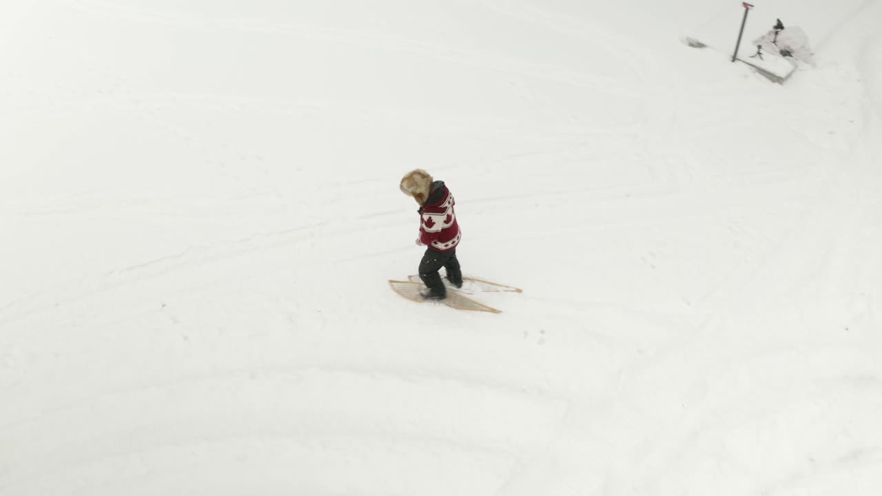 hombre adulto con un gran sombrero de piel, camina y juega con raquetas de nieve tradicionales en un lago congelado con sus perros en el norte de canadá