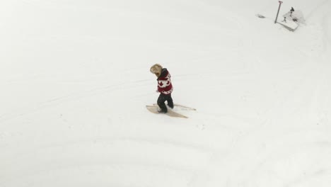 hombre adulto con un gran sombrero de piel, camina y juega con raquetas de nieve tradicionales en un lago congelado con sus perros en el norte de canadá