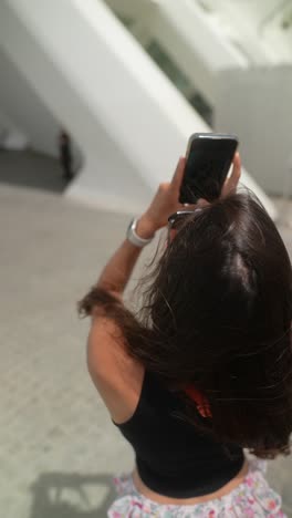 woman taking a picture in a city