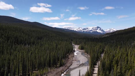 Luftaufnahme-Des-Flusses-In-Der-Nähe-Von-Crescent-Falls-Alberta-Kanada-Mit-Schneebedeckten-Bergen