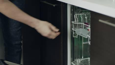 Closeup-man-hands-opening-dishwashing-machines-in-slow-motion