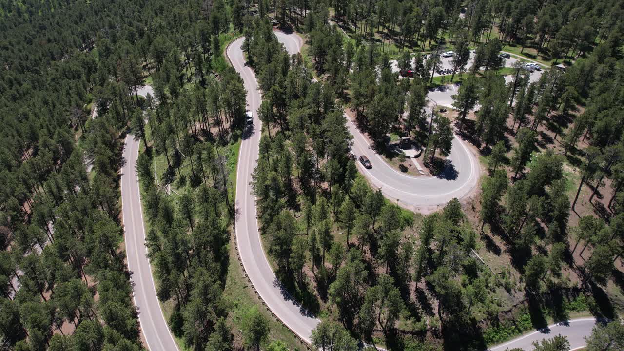 vista aérea de la carretera ventosa y el bosque de coníferas en el parque estatal custer, dakota del sur, ee.uu., disparo de drones