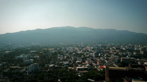 aerial scenic drone footage of the city of chiang mai, thailand covered in smog on a sunny day during the smokey burning season