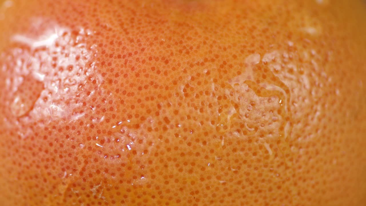 La buccia di pompelmo che gocciola gocce d'acqua.