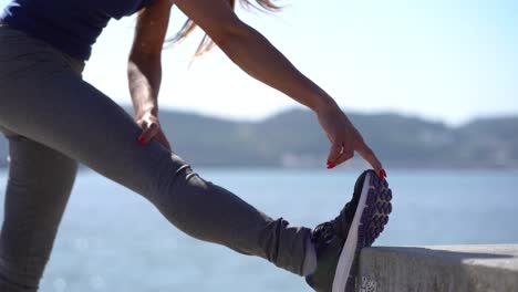 Athletic-young-woman-exercising-near-river