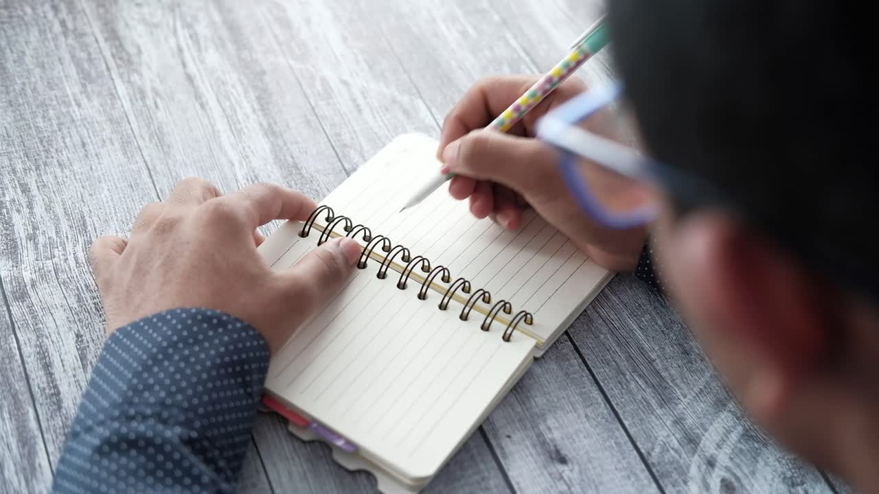 Person Writing in a Notebook