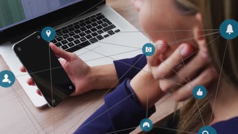 Animación-De-La-Red-De-Iconos-De-Medios-Sobre-Una-Mujer-Caucásica-Usando-Un-Teléfono-Inteligente-Y-Una-Computadora-Portátil