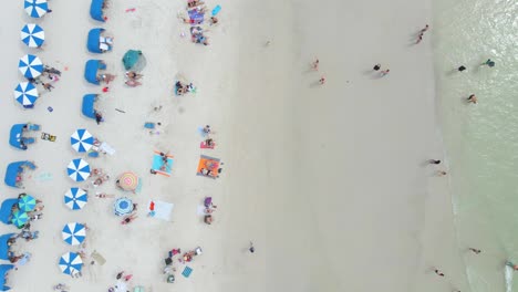 Vista-De-Arriba-Hacia-Abajo-De-La-Gente-En-Una-Hermosa-Playa-De-Arena-Blanca-En-Clearwater,-Florida