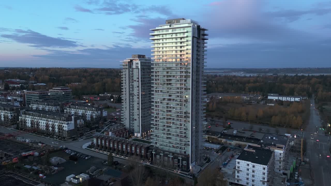 Carvolth, Langley City, Canada - Un'alta torre residenziale moderna si erge sopra gli edifici bassi circostanti durante una tranquilla prima serata - Scatto aereo con drone