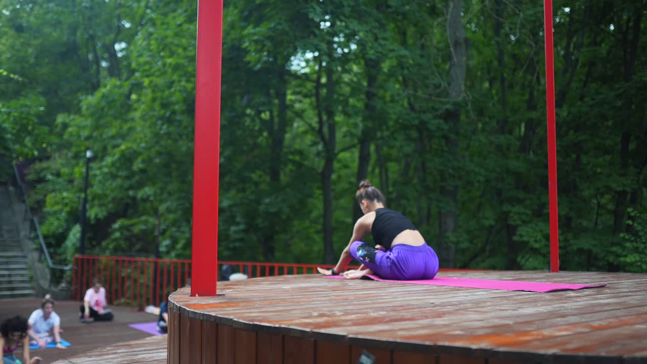공원 에서 야외 에서 요가 를 연습 하는 여자