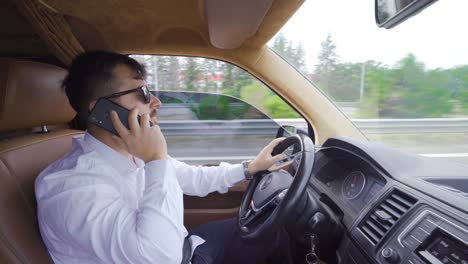 businessman talking on the phone while driving.