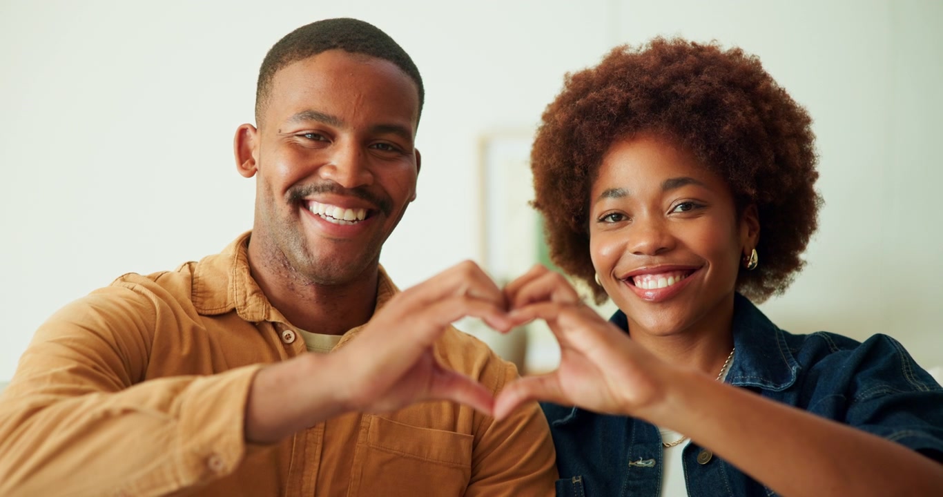 Happy Young Couple Making Heart Shape with Hands