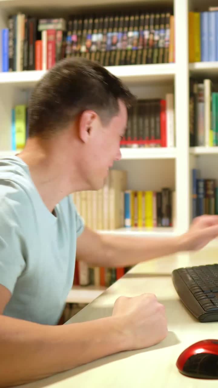 Man talking on the phone in front of a bookshelf