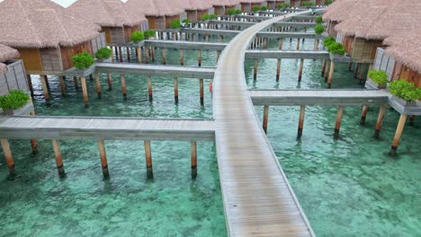 aerial view of overwater bungalows over turquoise lagoon, maldives. aerial drone at low altitude