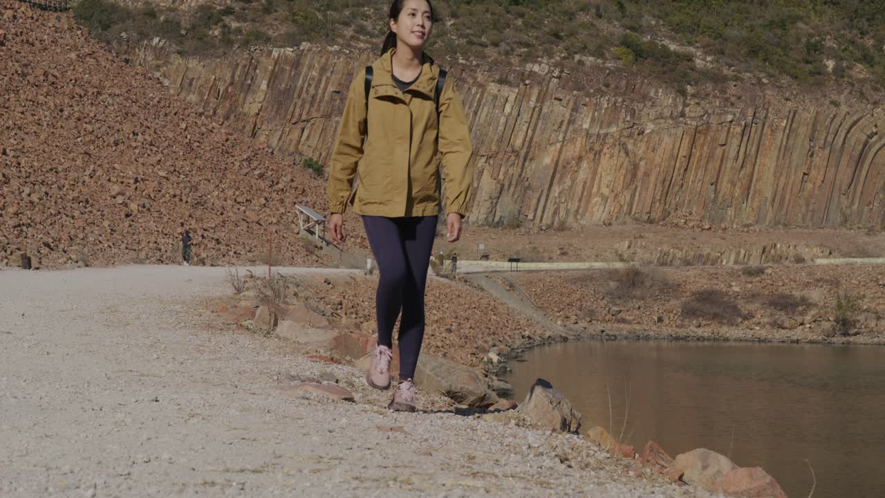 una mujer asiática caminando por el parque nacional.