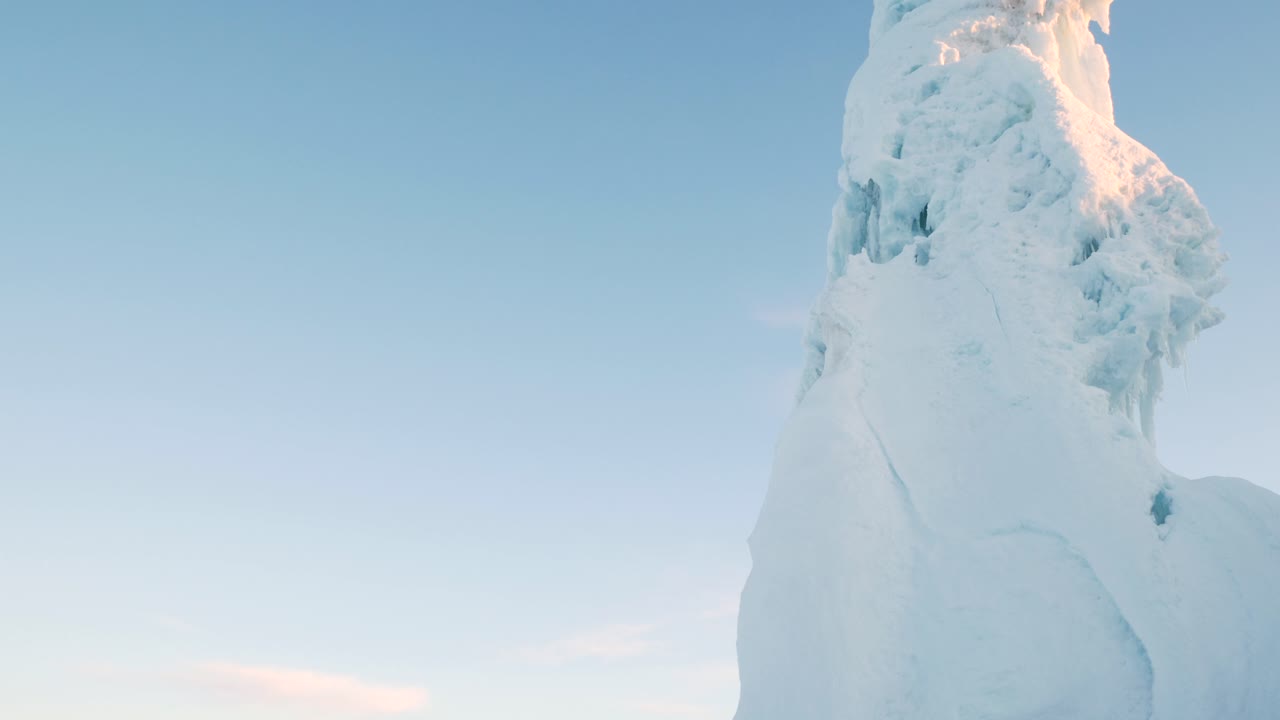 Hoher Eisberg in einer Kleinstadt in Nordschweden, von unten auf Stativ an einem kalten Morgen im März aufgenommen.