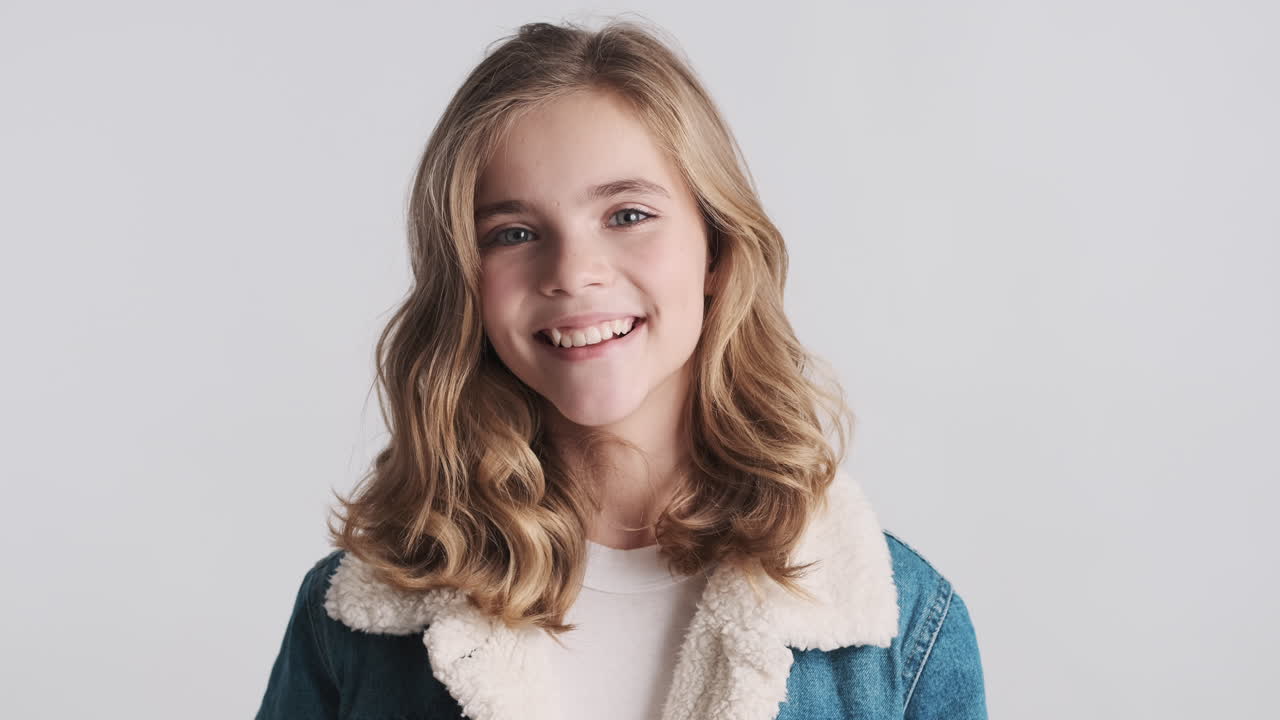 uma adolescente caucasiana feliz a usar uma jaqueta de jeans.