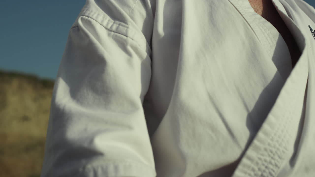 manos del deportista haciendo posición de karate en la naturaleza de cerca. hombre entrenando al aire libre