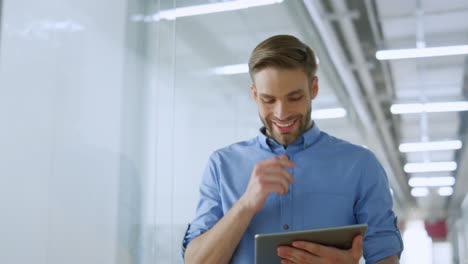 Excited-man-using-tablet-while-going-office.-Businessman-working-while-walking