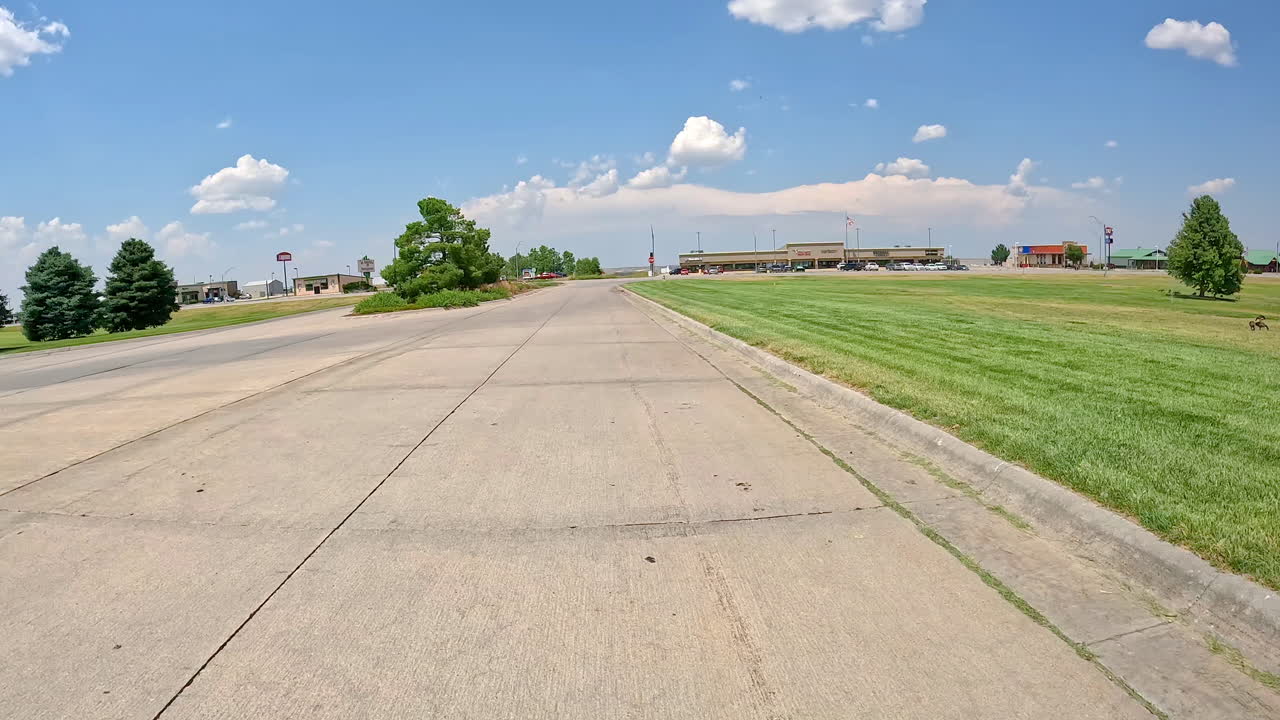 Scenic Roadside View with Shops and Greenery