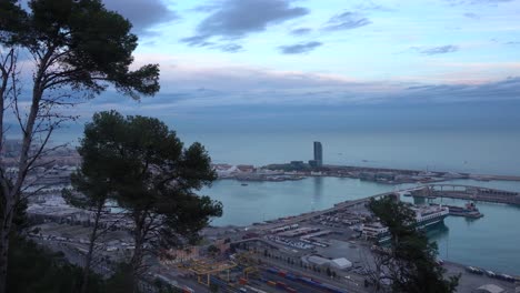 view of the port of barcelona from the heights of montjuïc on a partially clouded evening