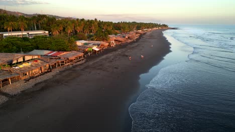 drone disparó playa de arena volcánica negra en la costa de el salvador al atardecer