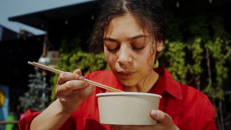 woman eating soup outdoors