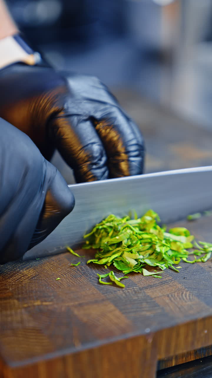 Parsley is cut on the wooden board. Healthy food preparation. Close up. Vertical video.