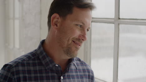 portrait-of-young-caucasian-man-smiling-looking-looking-out-window-pensive-contemplative-expressing-satisfaction