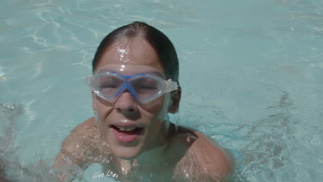 child swimming underwater in pool