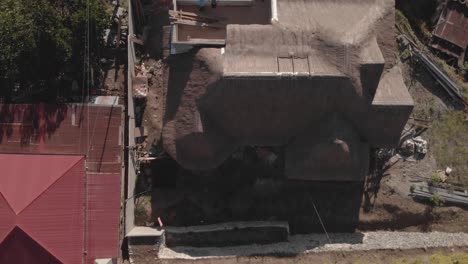 grass roof house hut in a mountain village red tops of homes farms in backyard with trails weaving through trees connecting community aerial rotating ascending wide angle birds eye view top down