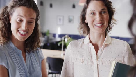 happy diverse female colleagues in discussion in casual office meeting, slow motion