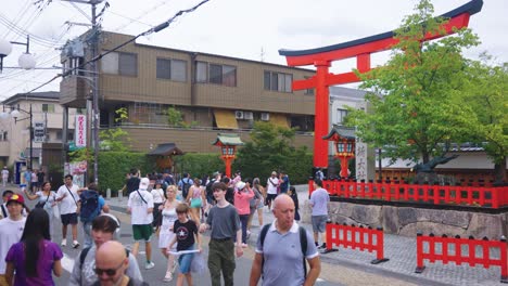 crowded street scene in japan with torii gate