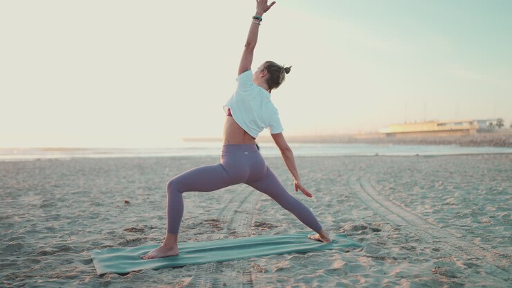 Vista trasera de chica deportista haciendo yoga en esterilla de fitness.