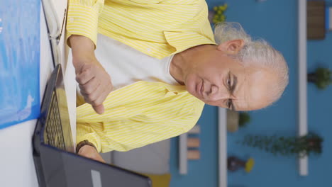 Vertical-video-of-Home-office-worker-old-man-nervously-waiting-at-laptop.