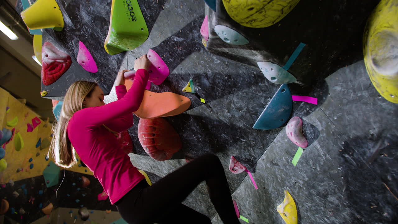 chica adolescente haciendo bouldering en el interior