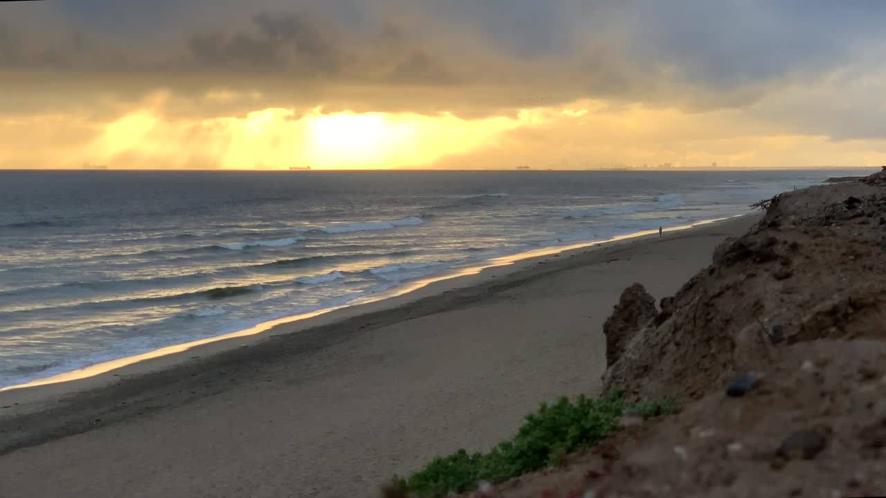 4k 60p, atardecer dorado en una playa con cielo nublado