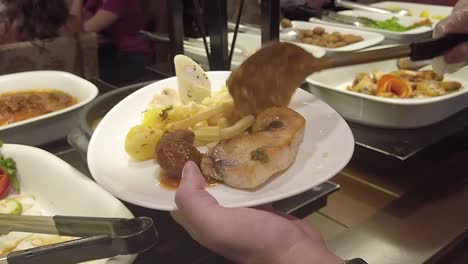 pouring a sticky goey meal on the dish during the lunch at a buffet restaurant in which you can eat all you can at all meals on a five star hotel