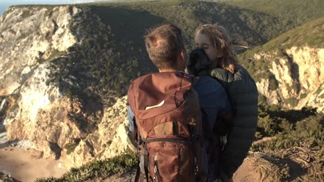 Strong-dad-with-camping-backpack-hugging-daughter-kid