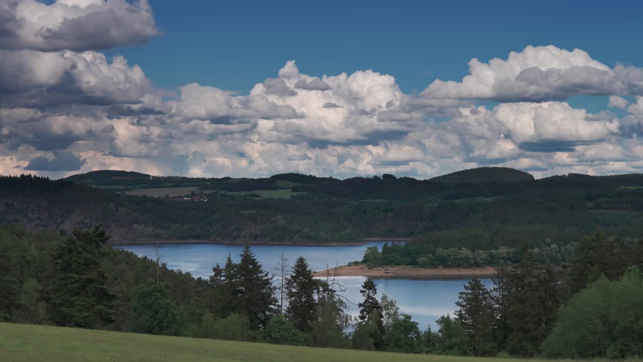 Dense Stormy clouds move in over a peaceful landscape creating a striking contrast of colors and moods