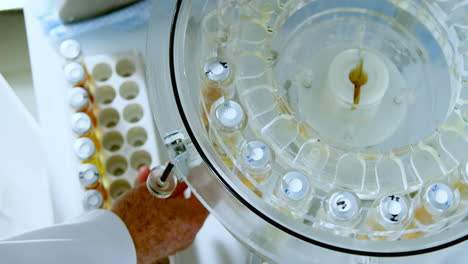 Male-scientist-removing-medical-vials-from-centrifuge-4k