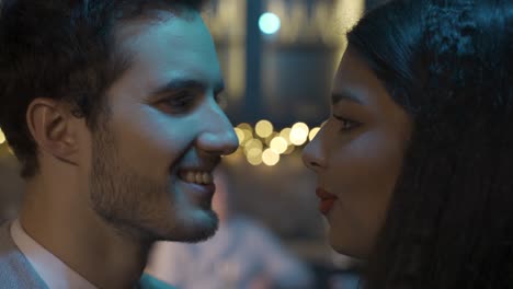 close-up view of a couple celebrating new year's eve party, they get closer and kiss while smiling