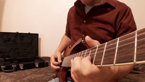 realizando calentamiento en una guitarra mientras toca el instrumento