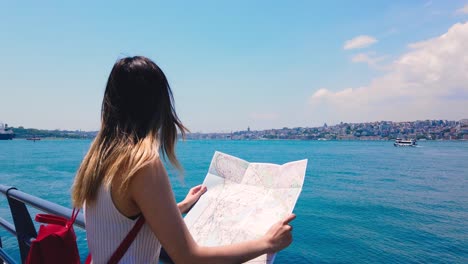 slow motion:beautiful girl looks map of istanbul with view of bosphorus,a popular destination in uskudar,istanbul,turkey