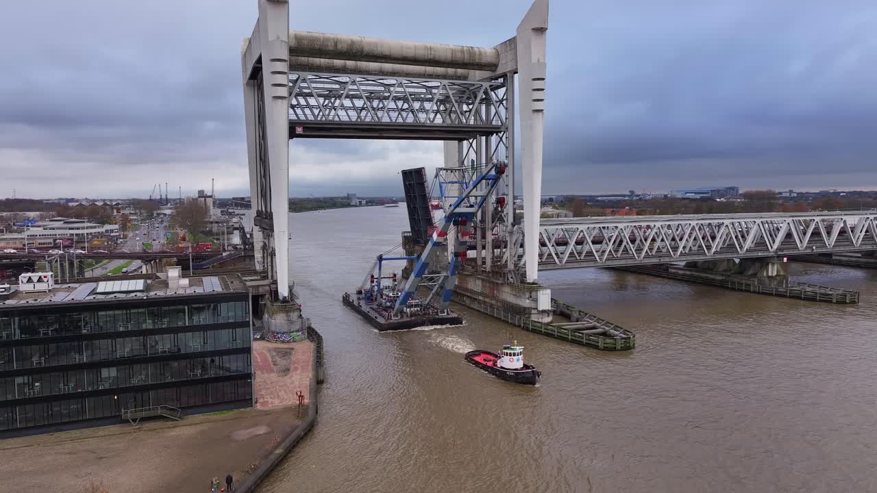 오든 매스 강을 따라 산업용 떠다니는 크레인을 동반하는 견인 보트