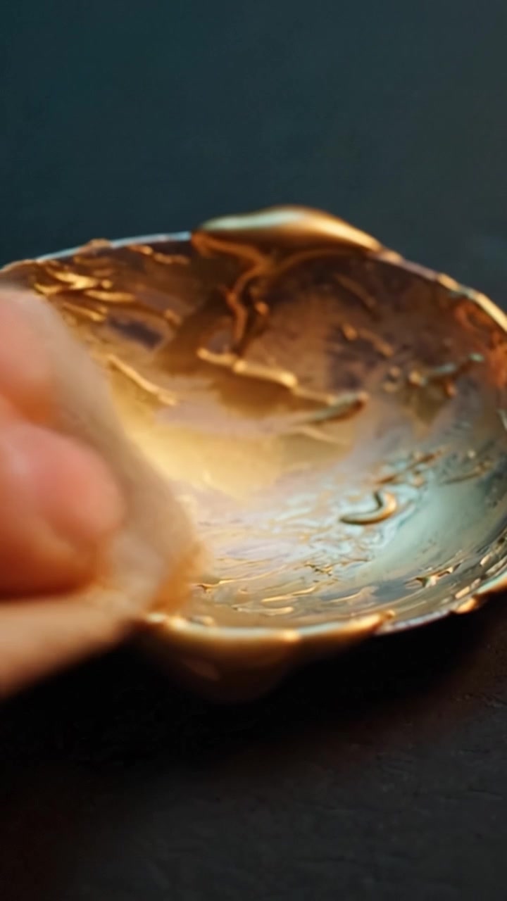 A Close-Up of Hands Working with a Shiny Gold Object, Showcasing the Intricate Textures and Details in the Material Across Different Frames of the Process
