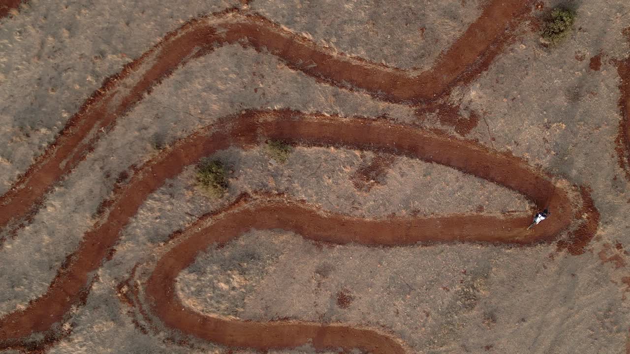 Mountain bike. Raider on circuit of mountain bike. Aerial view in ascend. MTB. Driving bicycles at high speed on a circuit with sharp curves. Granada. Spain.